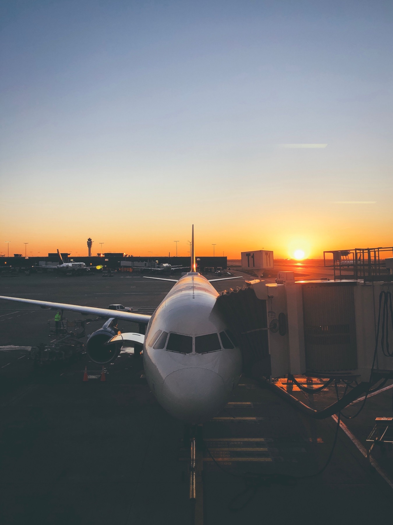 Airliner parked at an airport gate at sunrise