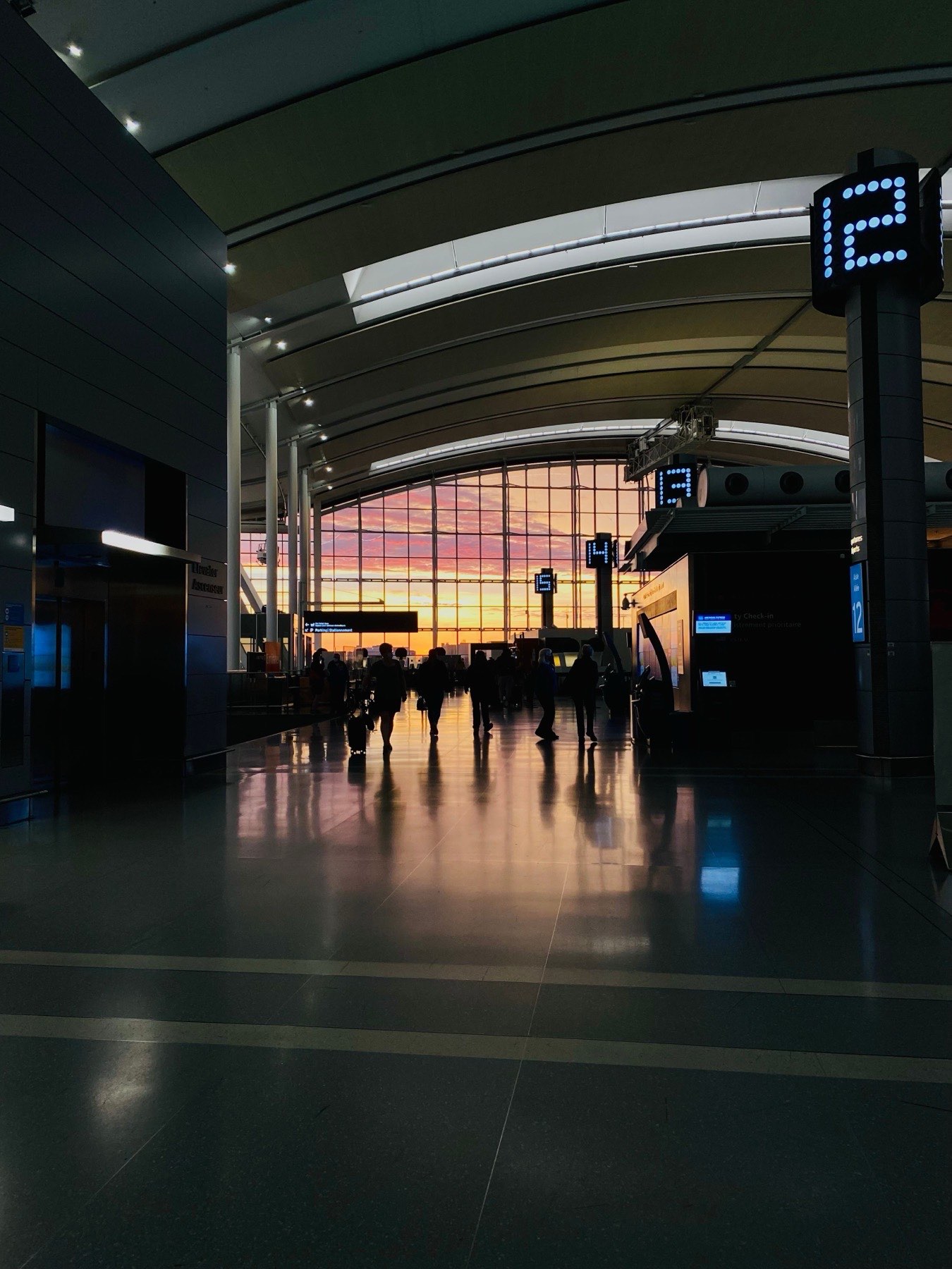 Travelers walking through an airport terminal at dusk