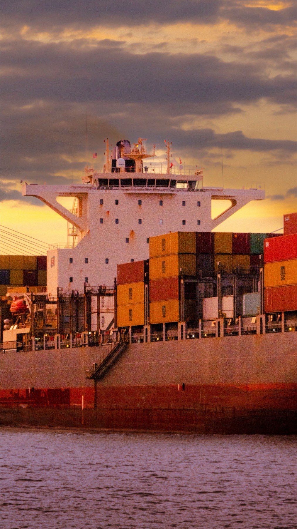 Container ship at port at sunset